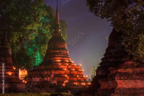Wat Mahathat illuminated by colorful light at night for Loy Krathong festival celebration in Sukhothai.