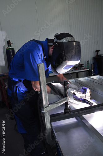 Welder at work at metalworking company (3)
