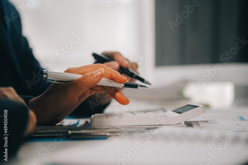 Financial analysts analyze business financial reports on a digital tablet planning investment project during a discussion at a meeting of corporate showing the results of their successful teamwork. photo