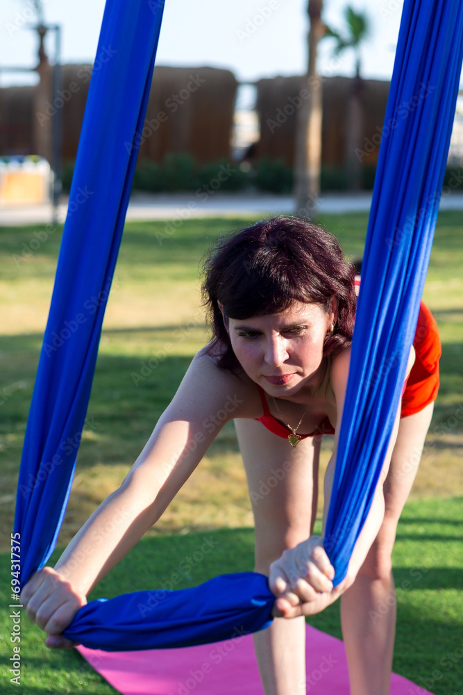 Fototapeta premium Group lesson aerial gymnastics on fabric outdoors.
