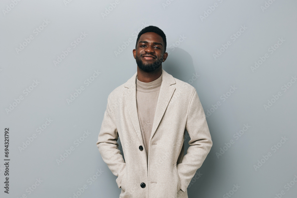 Happy young African American gen z guy isolated on beige background. Smiling hipster ethnic teen student, cool curly ethnic generation z teenager fashion model standing looking at camera, portrait. Happy young African American gen z guy isolated on beige background. Smiling hipster ethnic teen student, cool curly ethnic generation z teenager fashion model standing looking at camera, portrait.