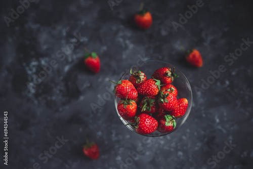 Healthy love concept, strawberry fruit on glass, black background. 