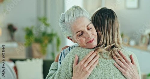 Love, comfort and woman hug senior mother in a living room with compassion, trust and empathy in their home. Mama, support and female person embrace elderly parent in a lounge with solidarity or care photo