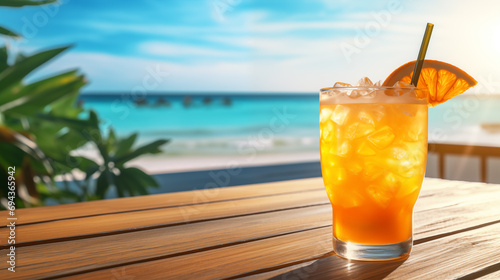 Orange cocktail with ice on the wooden table on the beach