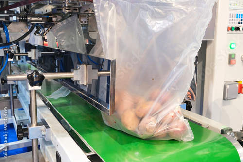 Food factory automated robotic machine. Conveyor product line for cooking and packing rations and food packs. packing potatoes in a plastic photo