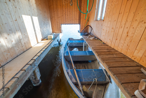 Fototapeta Naklejka Na Ścianę i Meble -  Close-up view of wooden boat in wooden parking house. Sweden.