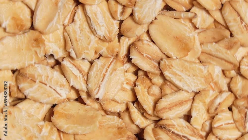 Oat Flakes Background Rotating Left - Top View, Close-Up. Scattered Dry Oat Flakes. Healthy Breakfast and Diet Eating Ingredients Oat Flakes Background Rotating Left - Top View, Close-Up. Scattered Dry Oat Flakes. Healthy Breakfast and Diet Eating Ingredients