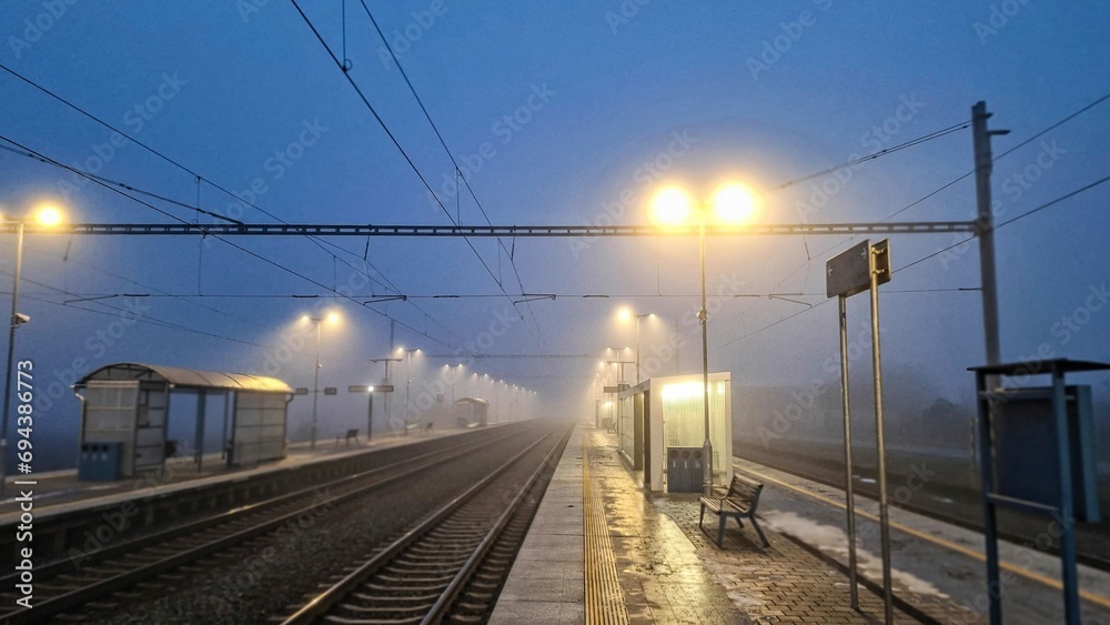 Night railway station. Abandoned railway station in fog. Concept of traveling, tourism or commuting to work