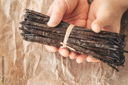 the world's best vanilla from Madagascar, premium quality, aromatic addition to cakes and desserts, a bunch of whole vanilla beans in paper, tasty and healthy organic additions in the kitchen photo