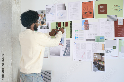  Male professional organizing documents on a mood board. Strategic Planning Session photo