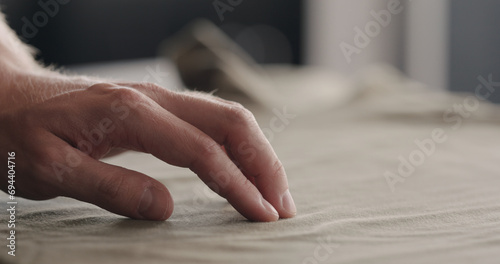 man touching taupe cotton clothes closeup photo