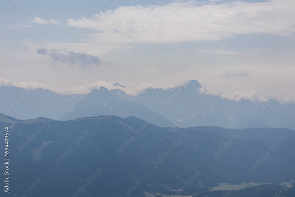 Scenic view from summit Dobratsch on Julian Alps and Karawanks mountain ranges in Carinthia, Austria, Europe. Jagged sharp peaks in Austrian Alps. Wanderlust tranquil atmosphere in alpine wilderness