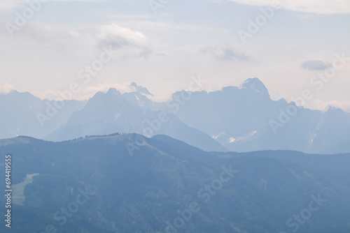 Scenic view from summit Dobratsch on Julian Alps and Karawanks mountain ranges in Carinthia, Austria, Europe. Jagged sharp peaks in Austrian Alps. Wanderlust tranquil atmosphere in alpine wilderness © Chris