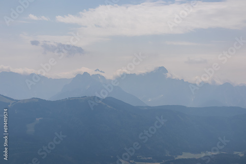 Scenic view from summit Dobratsch on Julian Alps and Karawanks mountain ranges in Carinthia  Austria  Europe. Jagged sharp peaks in Austrian Alps. Wanderlust tranquil atmosphere in alpine wilderness