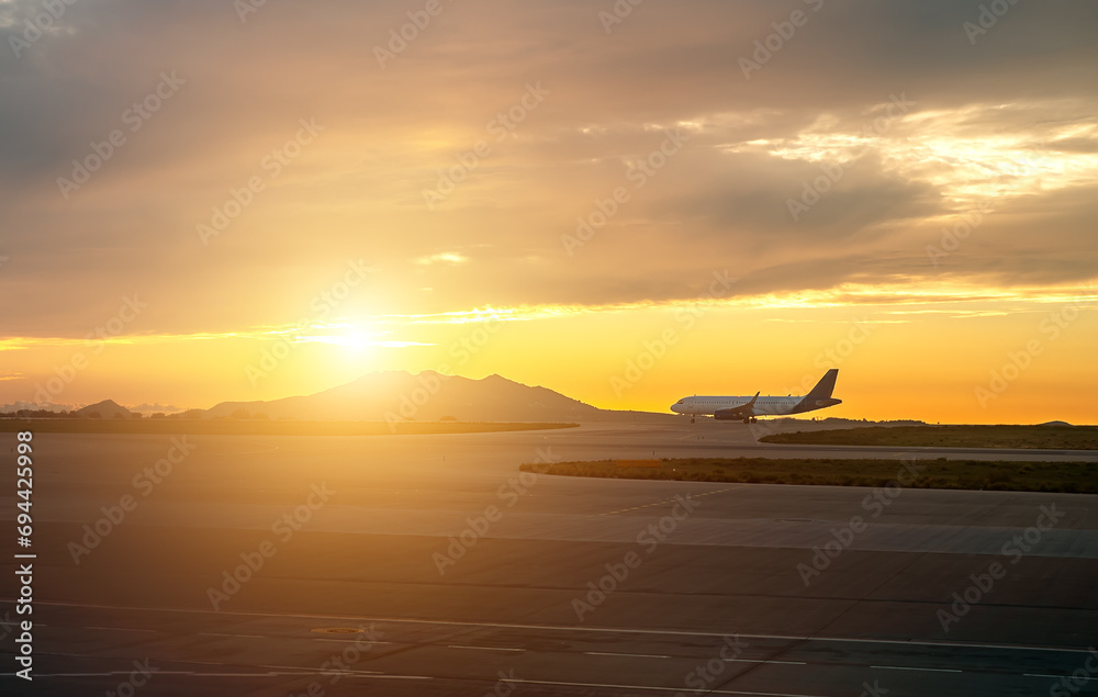 Commercial plane prepares to take off at sunset.