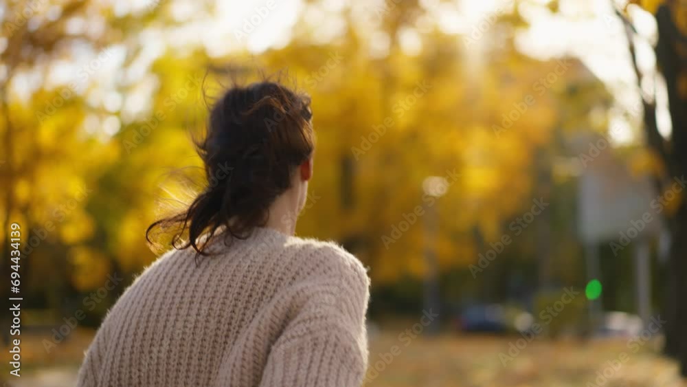back view stunning young brunette woman joyfully running in autumn park with yellow foliage. happy attractive girl in retro casual wear walks in park at warm fall day. slow motion 4k footage back view stunning young brunette woman joyfully running in autumn park with yellow foliage. happy attractive girl in retro casual wear walks in park at warm fall day. slow motion 4k footage