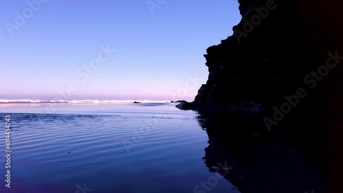 Untransparent video clip of Las Catedrales beach showing the crystal clear water with a natural mirror effect where you can see the waves that characterize this emblematic tourist place in Galicia. photo
