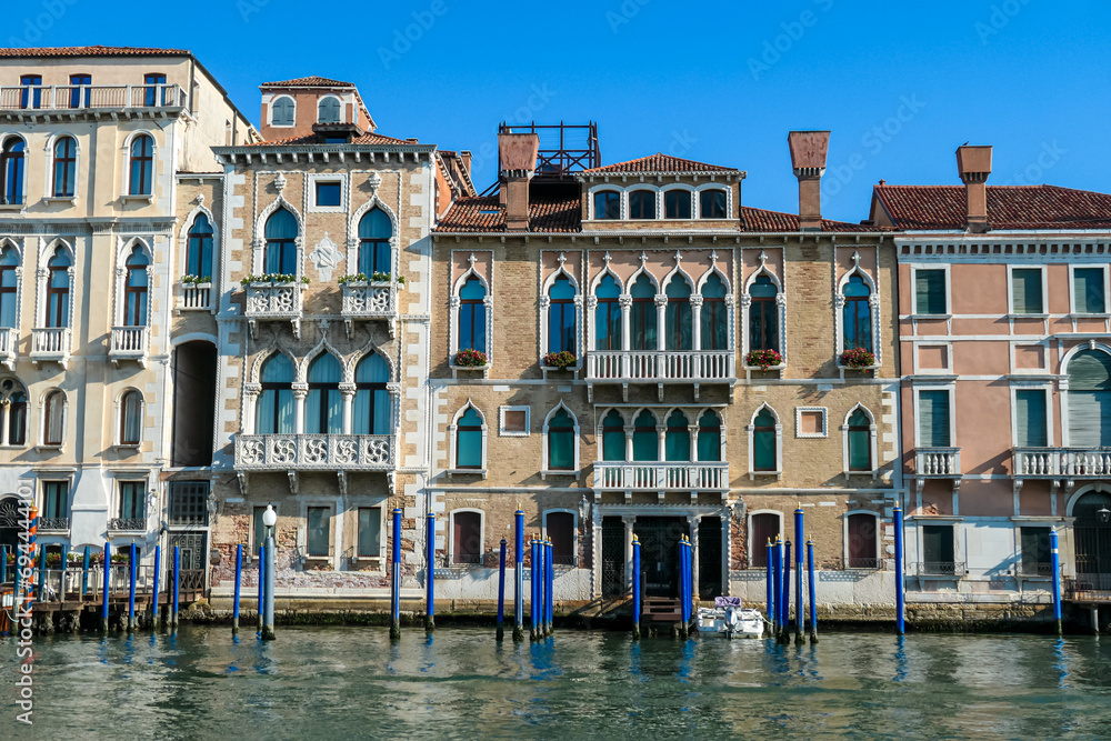 Scenic  view of Grand Canal (Grand Canale) in Venice, Veneto, Italy, Europe. Luxury residential house area along the biggest water channel. Golden hour on the facades. Urban summer tourism