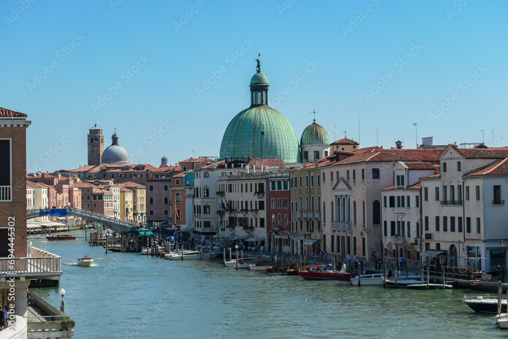 Panoramic view of the Grand Canal in city of Venice, Veneto, Italy, Europe. Famous landmark cathedral San Simeon Piccolo along the water traffic corridor Grand Canale. Urban tourism in summer