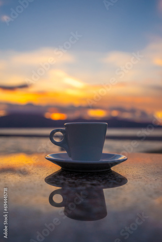 Cup of coffee on a table over blue sky and sea. Summer holiday concept