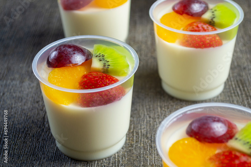 puding sutra leci or lychee silk pudding with kiwi, grape, orange and strawberry pieces on top. has a soft texture and tastes fresh. healthy food photo