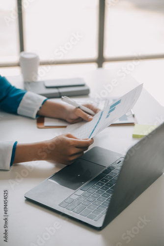 Shot of a asian young business Female working on laptop in her workstation.