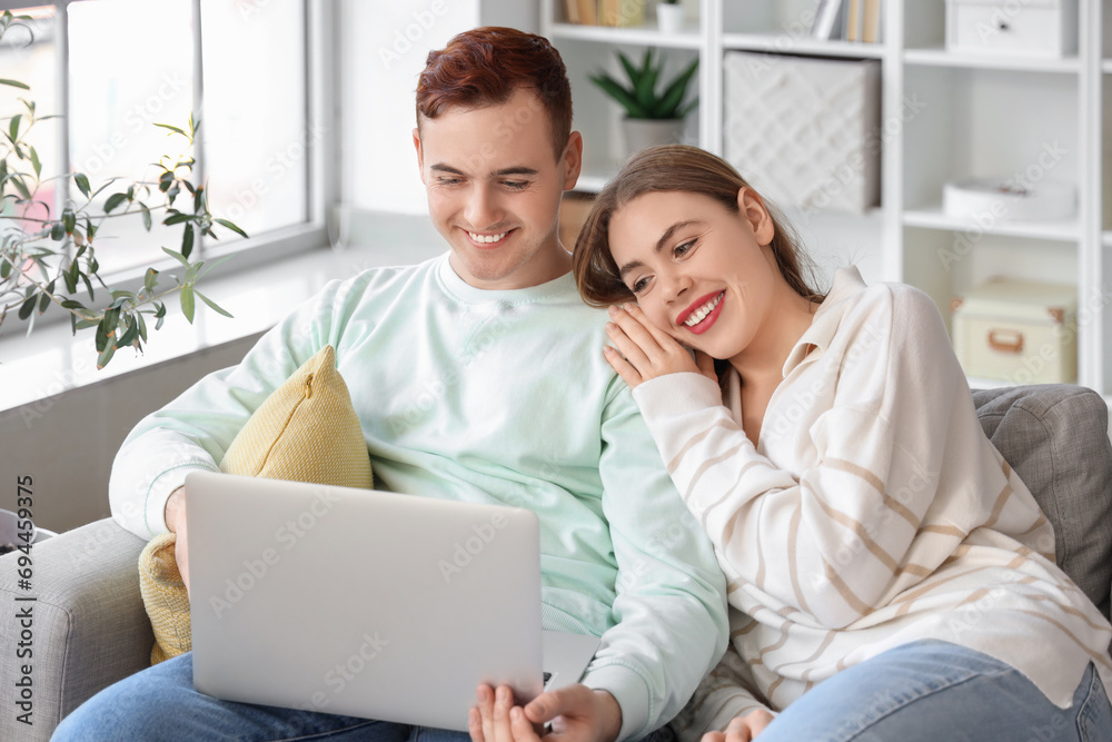Happy young couple with laptop watching video at home Happy young couple with laptop watching video at home