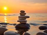 Pyramid stones on the seashore with warm sunset on the sea ocean background. Sandy beach, calm sea. Concept of happy vacation on the sea. Close-up of stacked pebbles at beach against sky during sunset