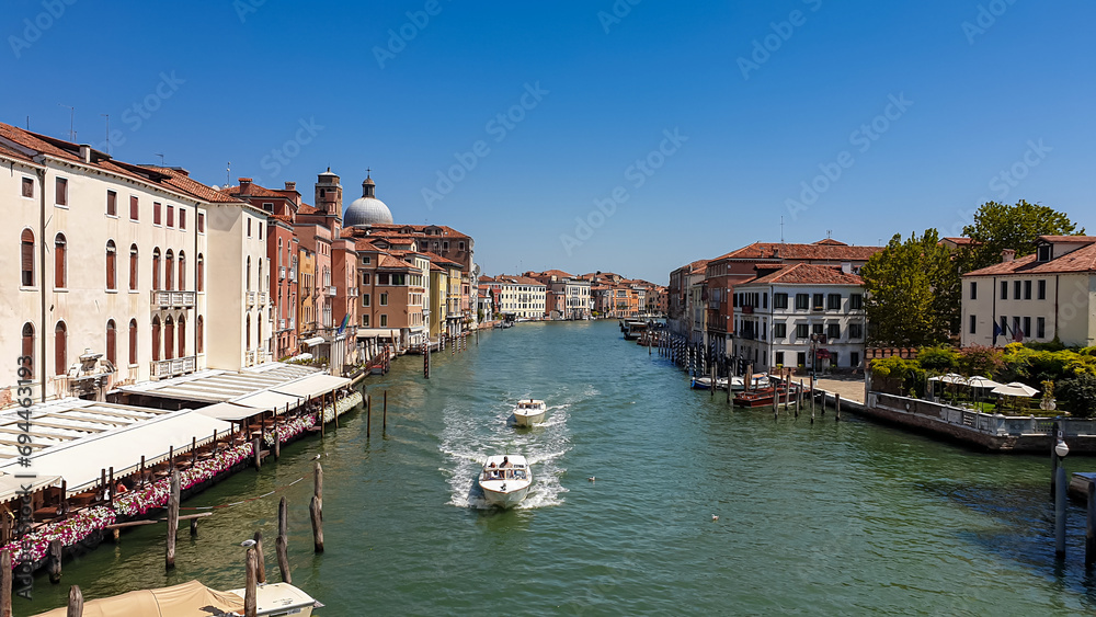 Panoramic view of water channel grand canale in city of Venice, Veneto, Northern Italy, Europe. Venetian architectural landmarks and old houses facades seen from gondola. Urban tourism in summer