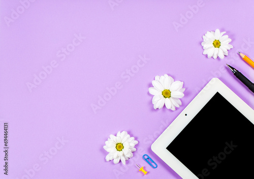 Stationery items tablet on a purple background, office photo