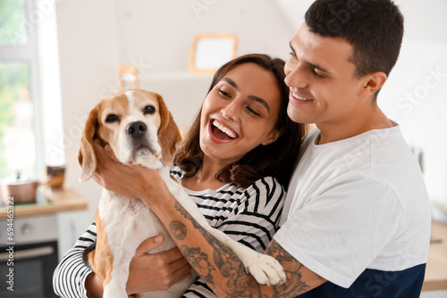 Young couple with cute Beagle dog at home © Pixel-Shot