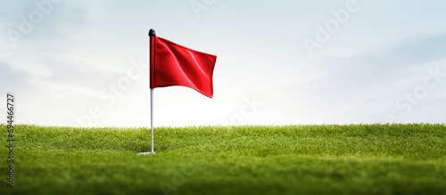 Golf club's red flag and hole.