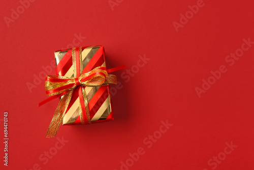Christmas gift box on red background © Pixel-Shot