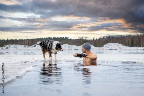 Strong man taking an ice bath. Swimming in a frozen lake during winter. Healthy cold swim.