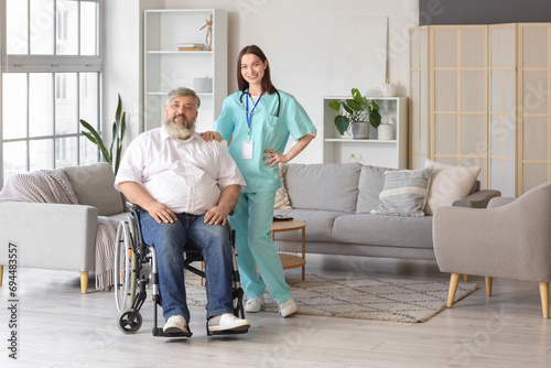 Mature man in wheelchair with nurse at home © Pixel-Shot