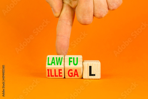 Lawful or illegal symbol. Concept word Lawful or Illegal on wooden cubes. Beautiful orange table orange background. Businessman hand. Business lawful or illegal concept. Copy space.