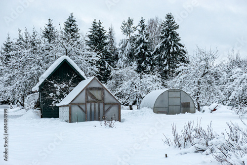garden in winter, covered with snow, fruit trees, garden house and garden accessories © ANDA
