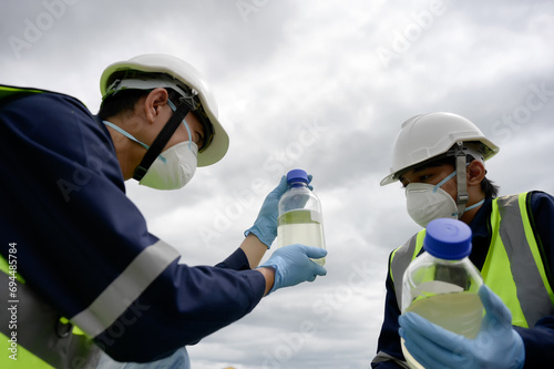 Environmental Engineers Team Take Water Samples at Natural Water Sources in a bottle. Water that smells bad Near Farmland May Be Contaminated by Toxic Suspicious Pollution Sites.