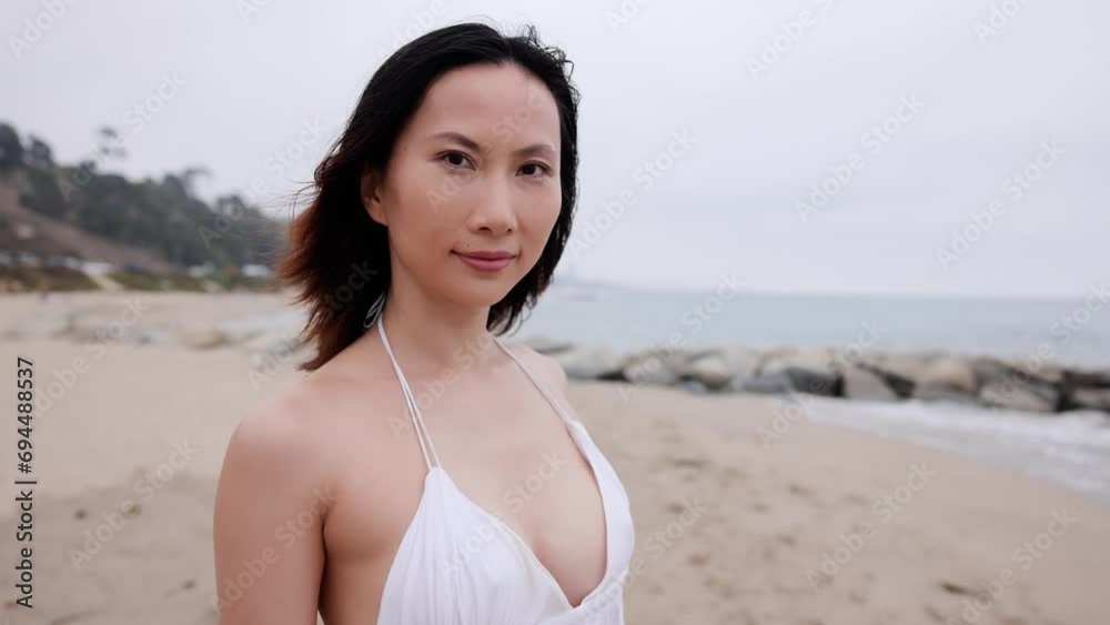 Attractive Asian woman in a white dress walking on the beach in Santa Monica California. Slow Motion. Attractive Asian woman in a white dress walking on the beach in Santa Monica California. Slow Motion.