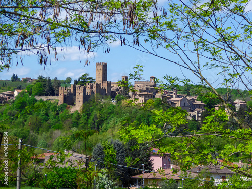 Scenic view of Medieval towns and castles of Emilia Romagna, Italy, Europe. Castel Arquato town and Rocca Viscontea castle on hill surrounded by greenery. Tranquil and calm scenery. Clear blue sky photo