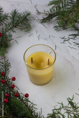 Homemade orange candle. Candles with a wooden wick on the background of spruce branches