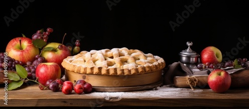 Apple pie with fruit on a table made of wood.