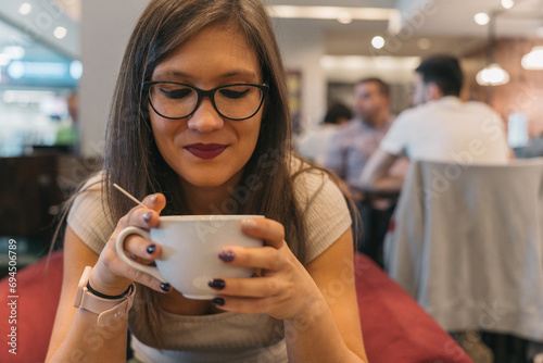 Young woman looking forward to her delicious coffee. Close up image of a girl about to drink her freshly brewed coffee while waiting for her next flight at an airport cafe.