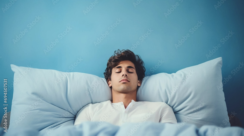 copy space, Young man taking a nap on a pillow on background. National Napping Day. Young man resting while tired. Peaceful scene. copy space, Young man taking a nap on a pillow on background. National Napping Day. Young man resting while tired. Peaceful scene.
