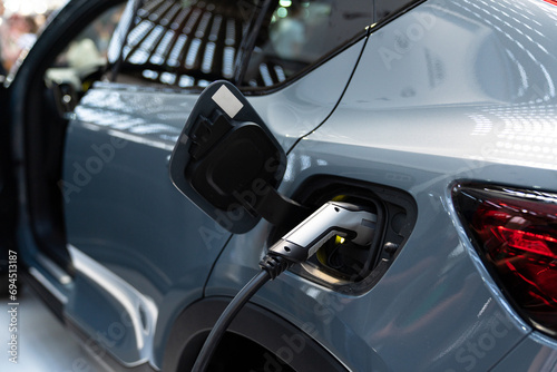 Close up of electric car inlet with a connected charging cable. © scharfsinn86