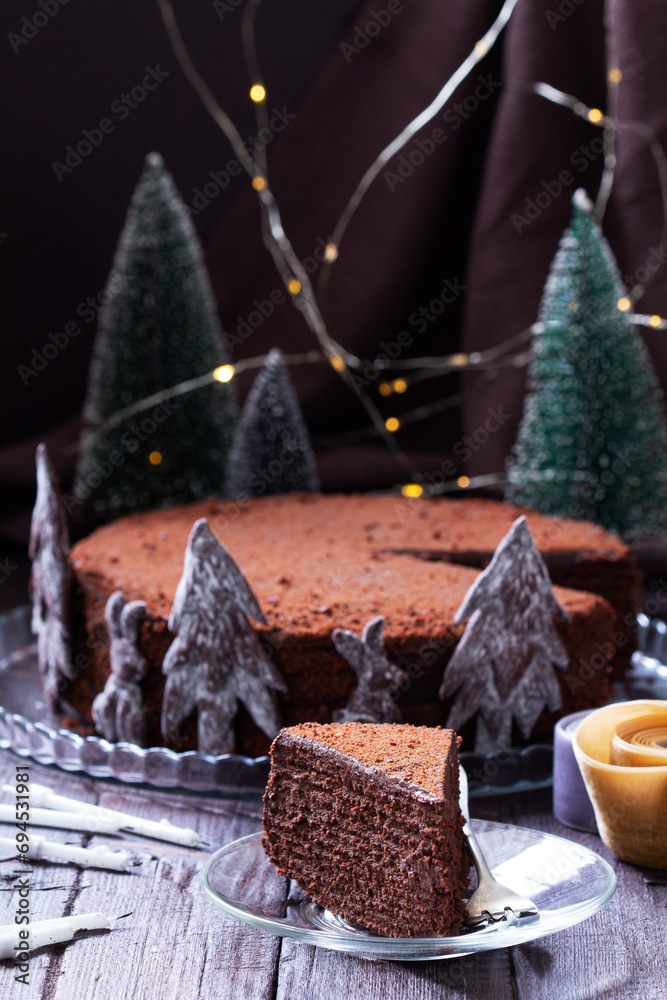 Chocolate honey cake in a Christmas decoration on a wooden background.