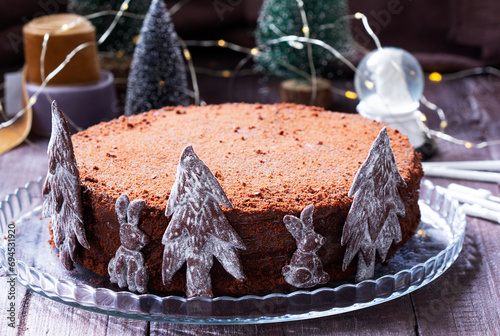 Obraz na płótnie Chocolate honey cake in a Christmas decoration on a wooden background. w salonie
