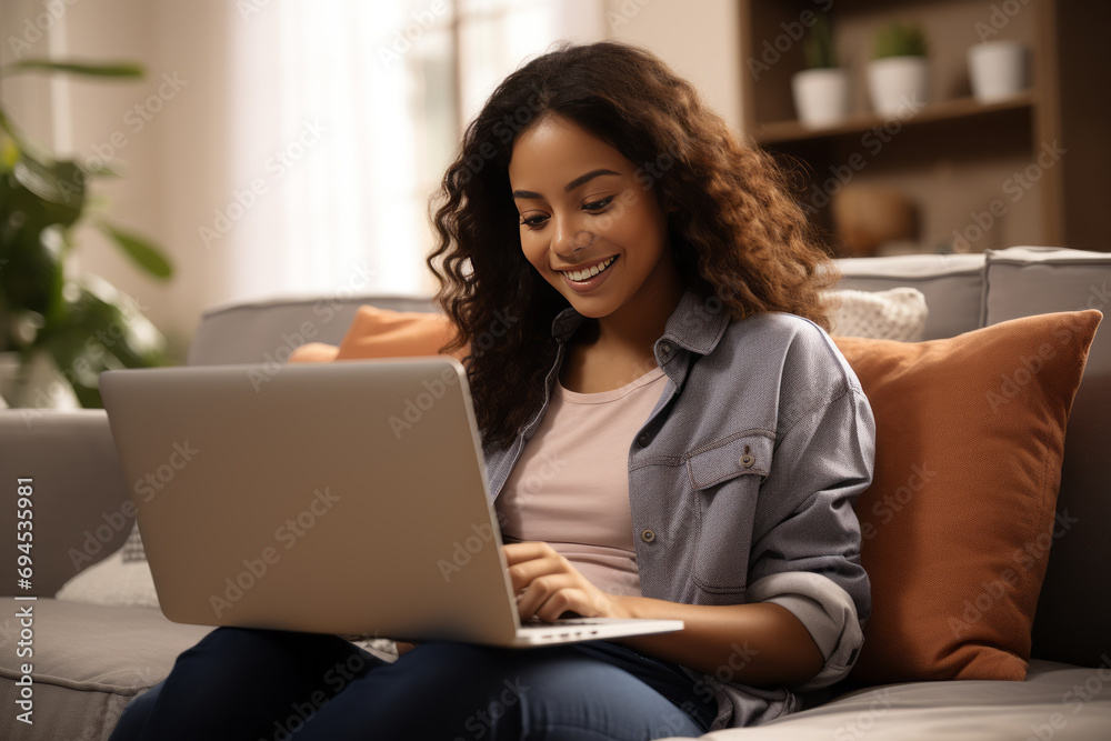 Young stylish woman freelancer with curly hair working on a laptop computer at home. Young stylish woman freelancer with curly hair working on a laptop computer at home.