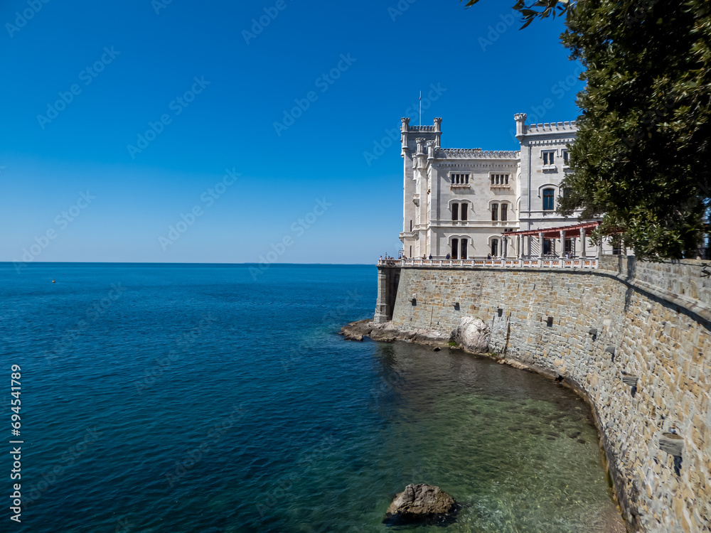 Scenic view of majestic historic white Miramare castle in Trieste in Friuli-Venezia Giulia, Italy, Europe. Blue sky in tranquil atmosphere at Adriatic Mediterranean sea in summer. Sightseeing