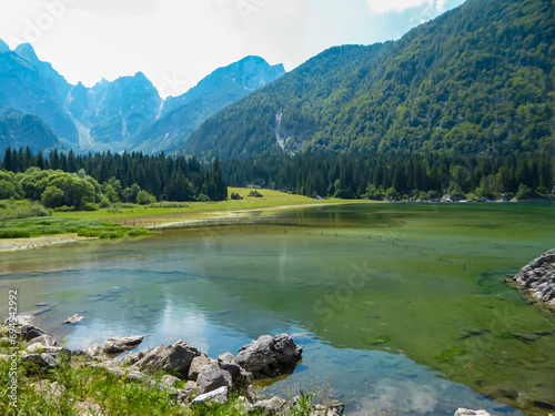 Scenic view of Superior Fusine Lake (Laghi di Fusine) in Tarvisio, Friuli-Venezia Giulia, Italy, Europe. Mount Mangart and Julian mountain range reflection in green alpine lake. Nature and wilderness